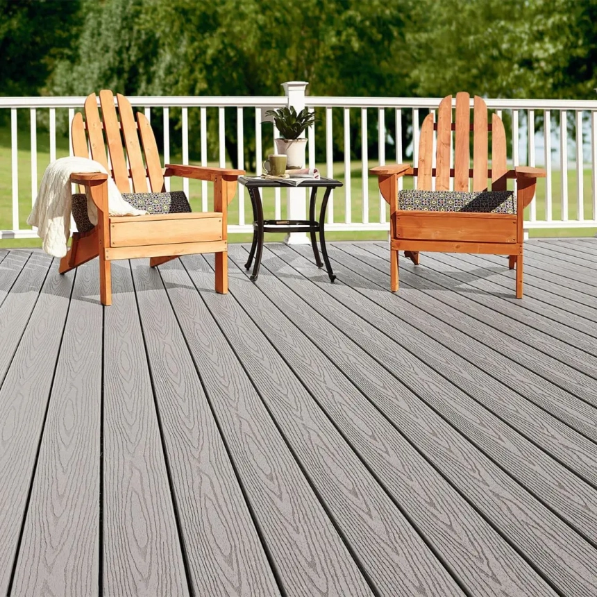 Rich-toned wood deck with Adirondack chairs overlooking a wooded lake, designed by custom wood deck builders.