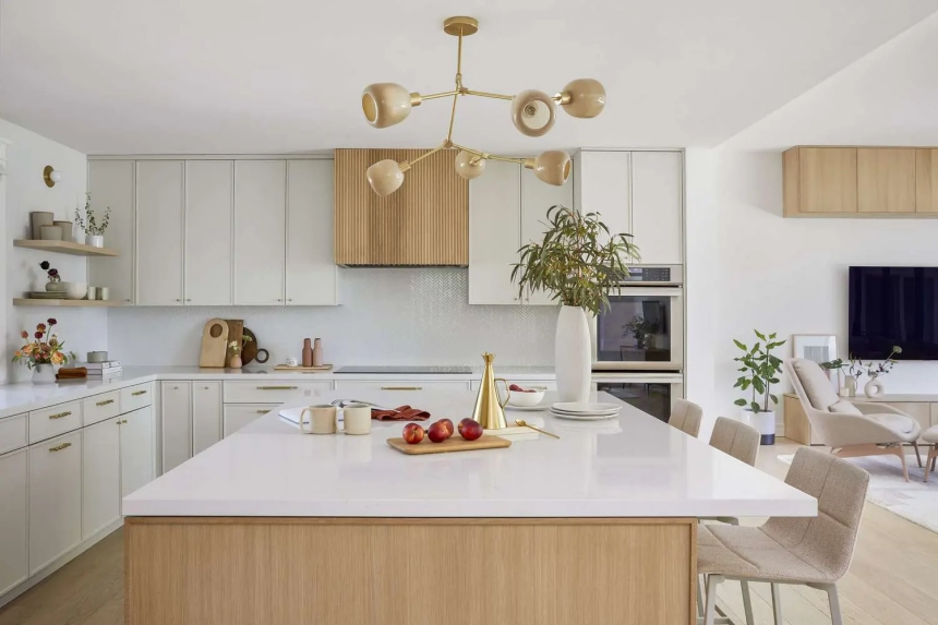 Modern kitchen design with light wood cabinetry, white countertops, minimalist decor, and a stylish chandelier. The kitchen includes open shelving, a center island with seating, and a built-in oven.