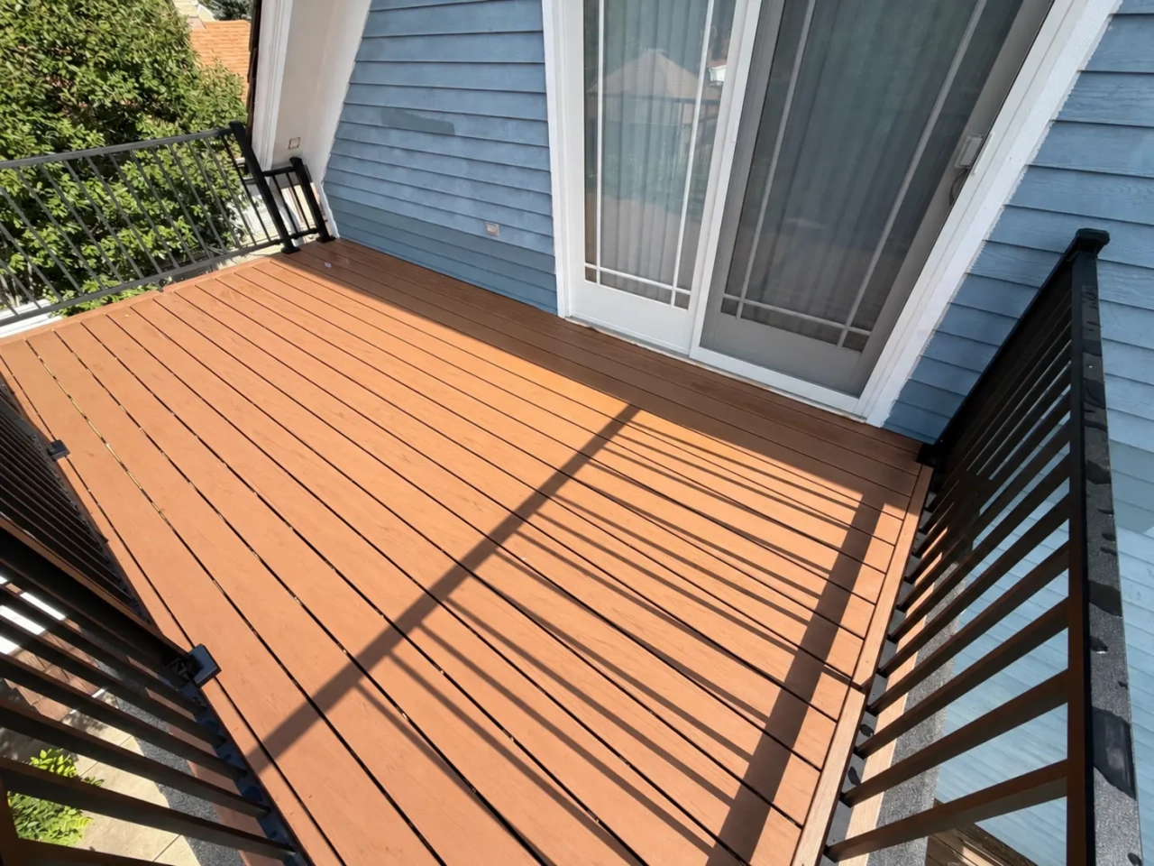 Finished Hatteras composite balcony decking with a picture-frame border and black picket railing.