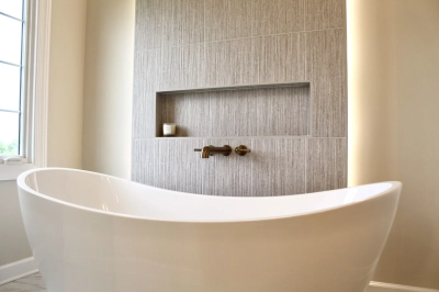 Freestanding bathtub with textured accent wall and built-in shelf