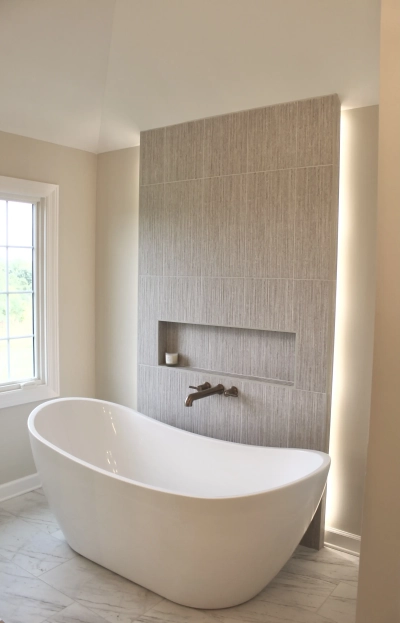 Freestanding bathtub with textured accent wall and built-in shelf