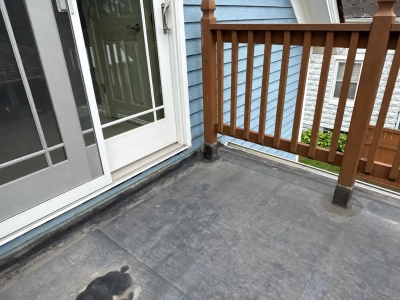 Original balcony flat roof beside patio doors with older wood railing before restoration in Plainfield, IL.