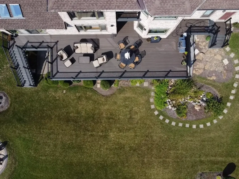 Aerial view of large gray composite deck with outdoor seating and pergola built by deck builder in Lombard IL