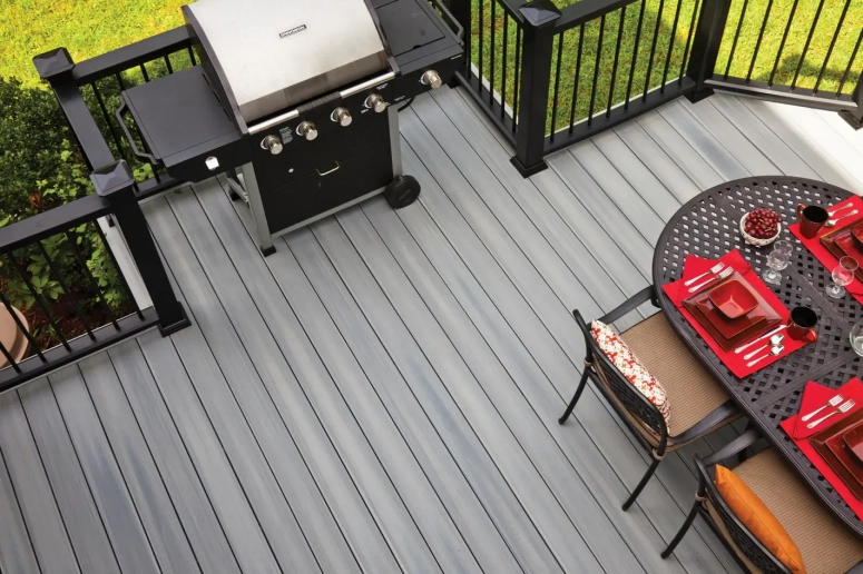 Gray composite deck boards with black railing and outdoor dining set installed by Oak Brook deck contractor