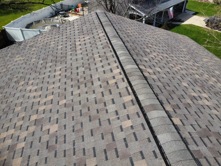 Aerial view of brown asphalt shingle roof with new ridge vent installed during roof repair in Wheaton Illinois