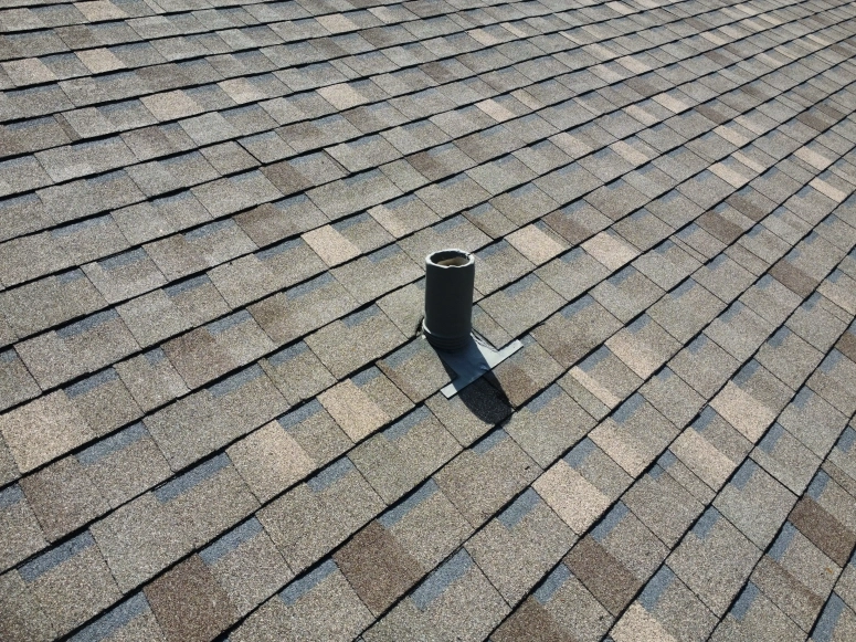 Close-up of asphalt shingle roof with repaired plumbing vent pipe boot flashing in Wheaton IL