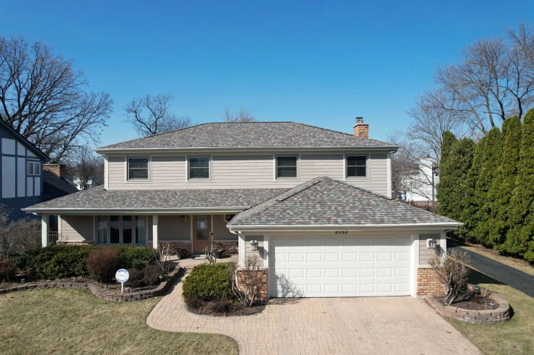 Front view of completed gray asphalt shingle roof replacement on two-story colonial home in Aurora Illinois