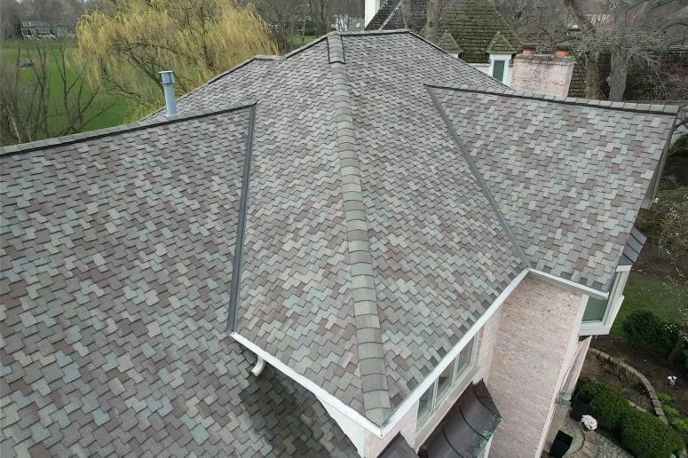 Close-up aerial view of new architectural shingle roof with ridge and hip details installed by roof replacement contractor in Ge
