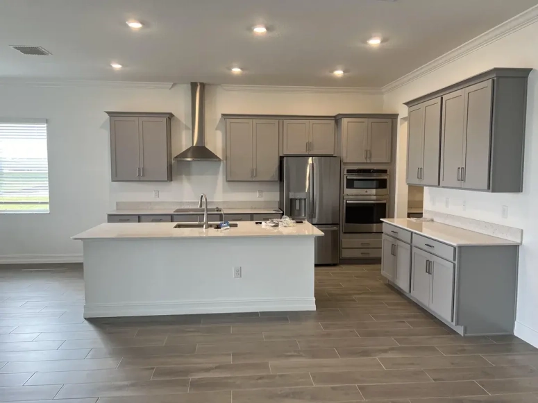 Gray shaker resurfaced kitchen cabinets with white island and stainless steel appliances